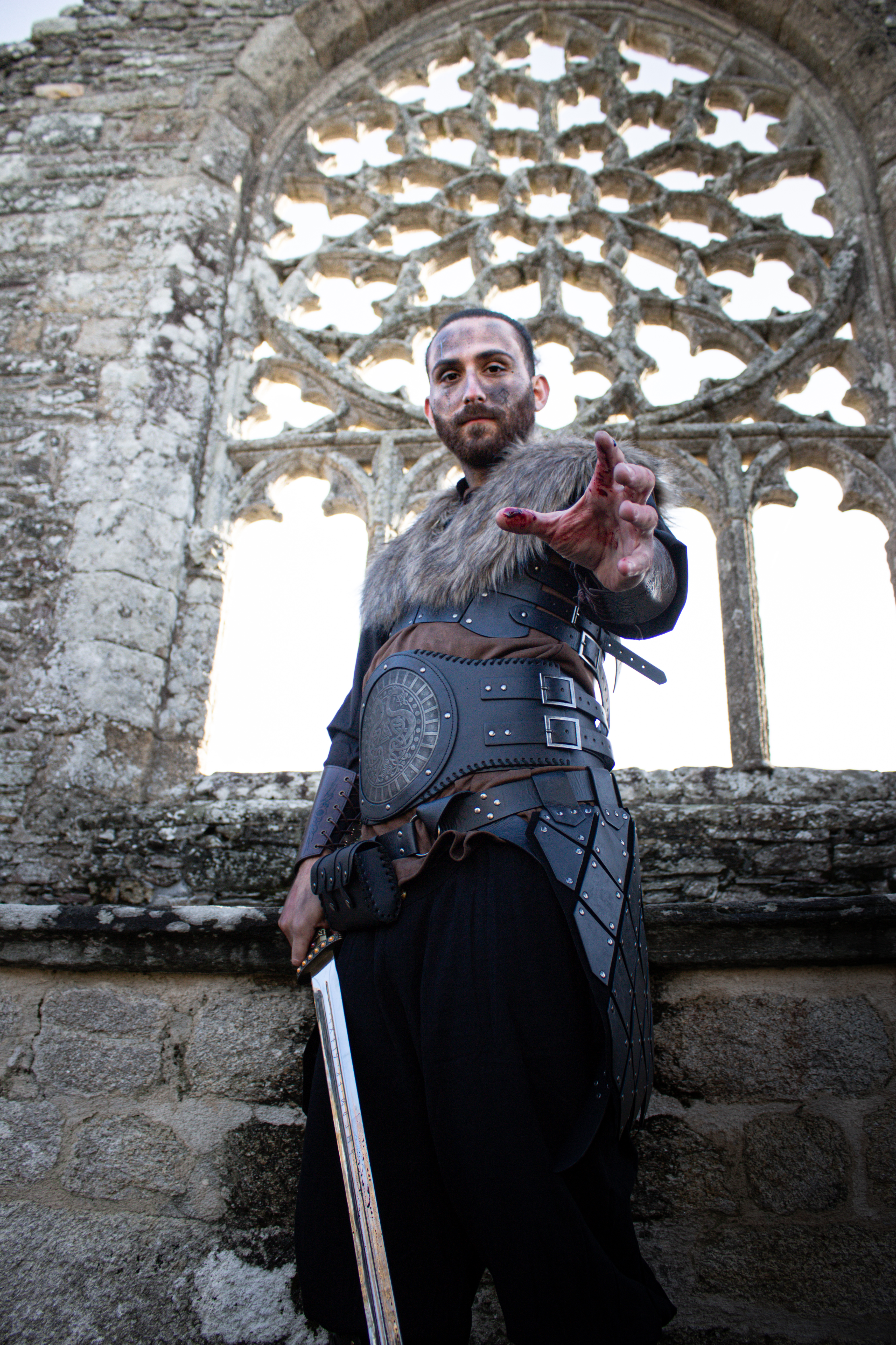 Guerrier viking tendant la main devant la rosace d’une abbaye en ruine