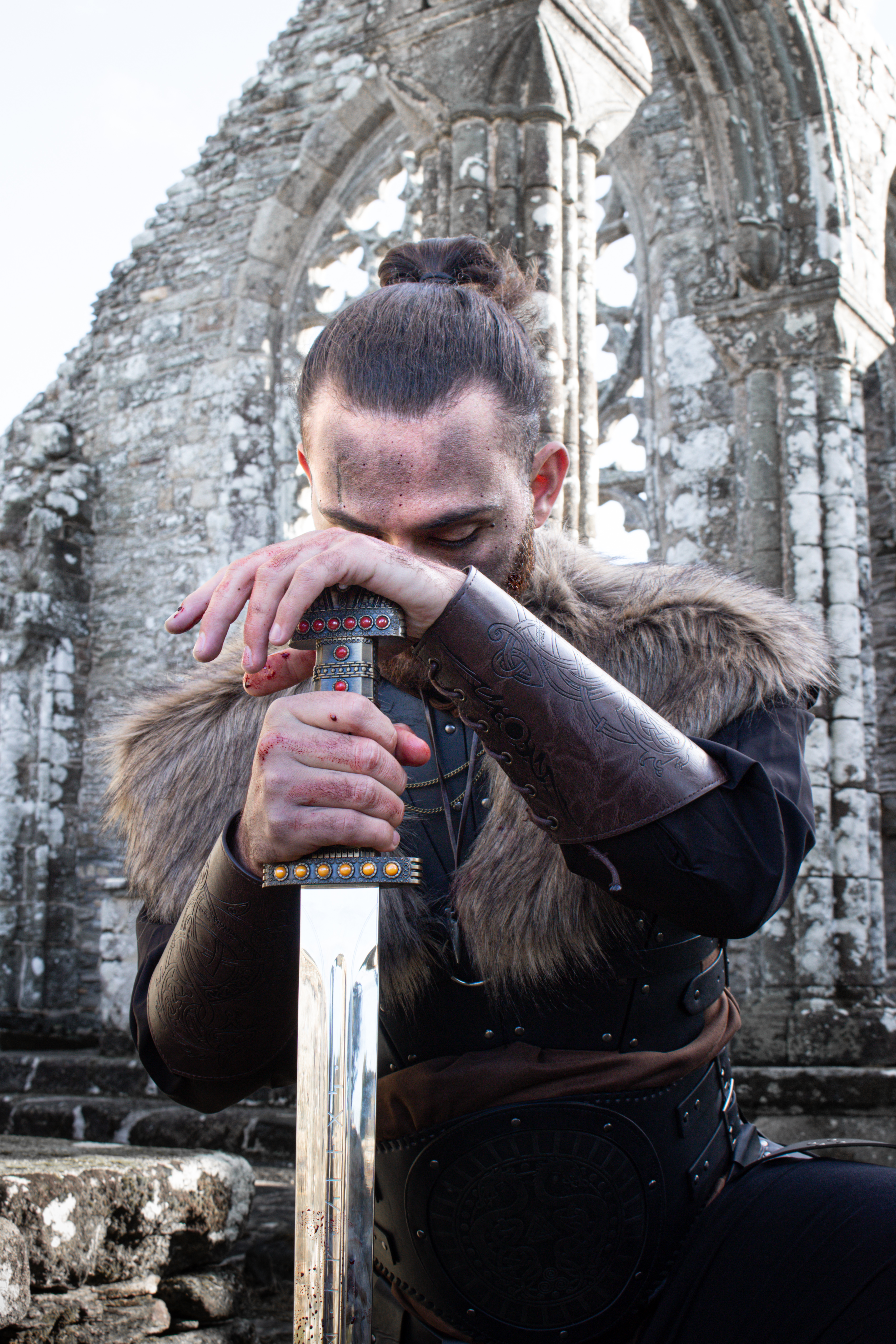 Guerrier viking recueilli, les mains posées sur le pommeau de son épée