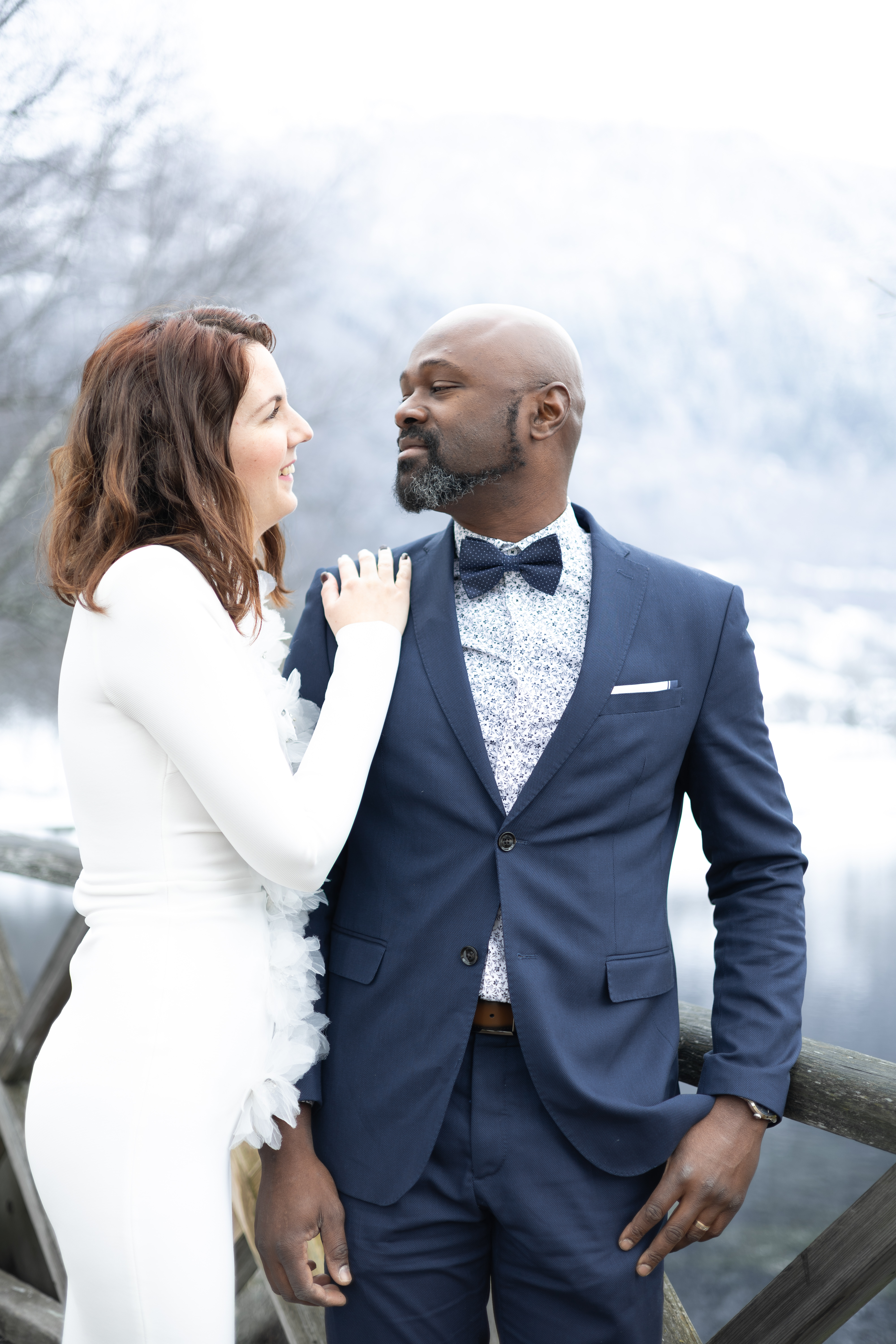 Mariée ajustant avec tendresse le revers du costume bleu de son époux