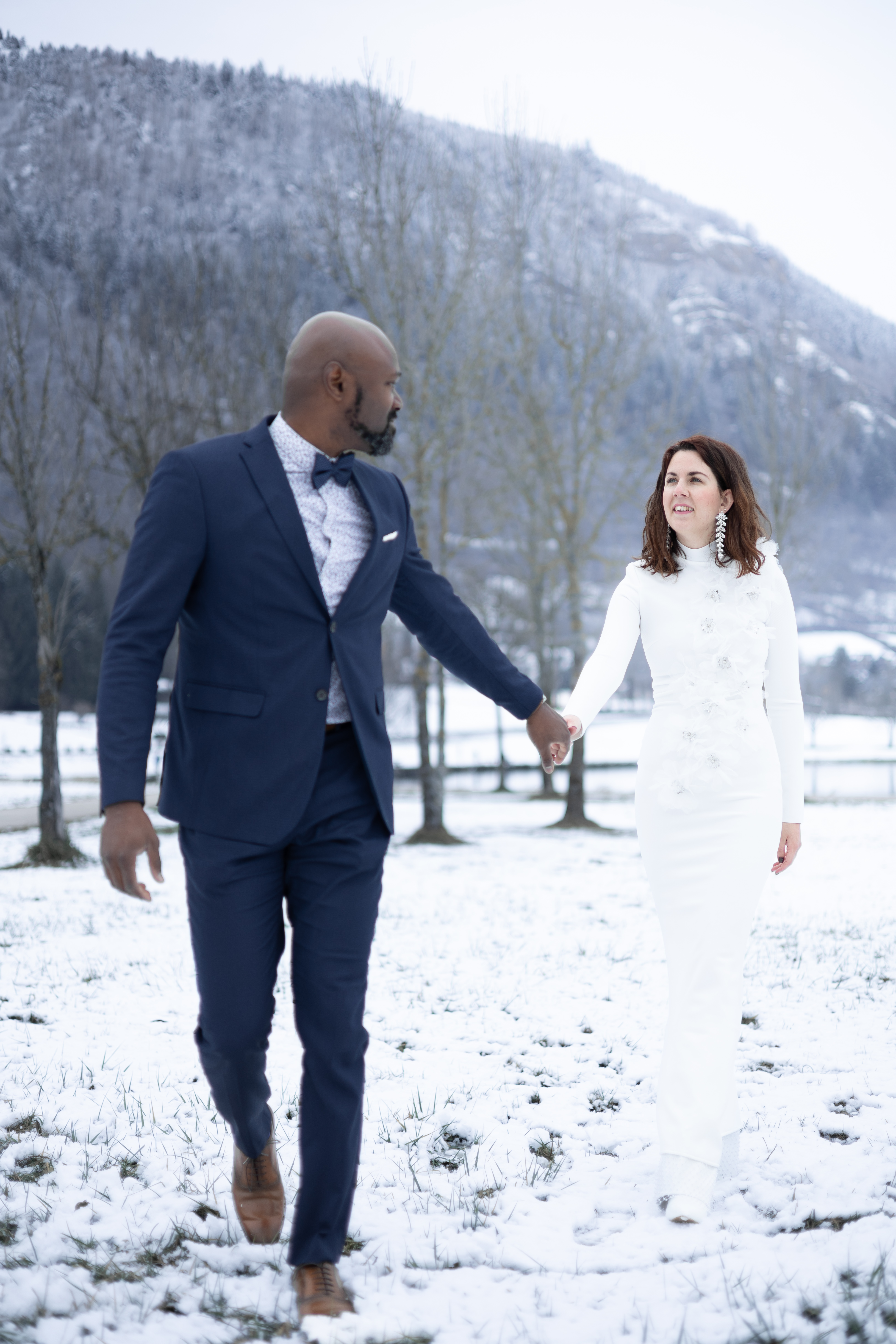 Jeunes mariés marchant main dans la main dans la neige