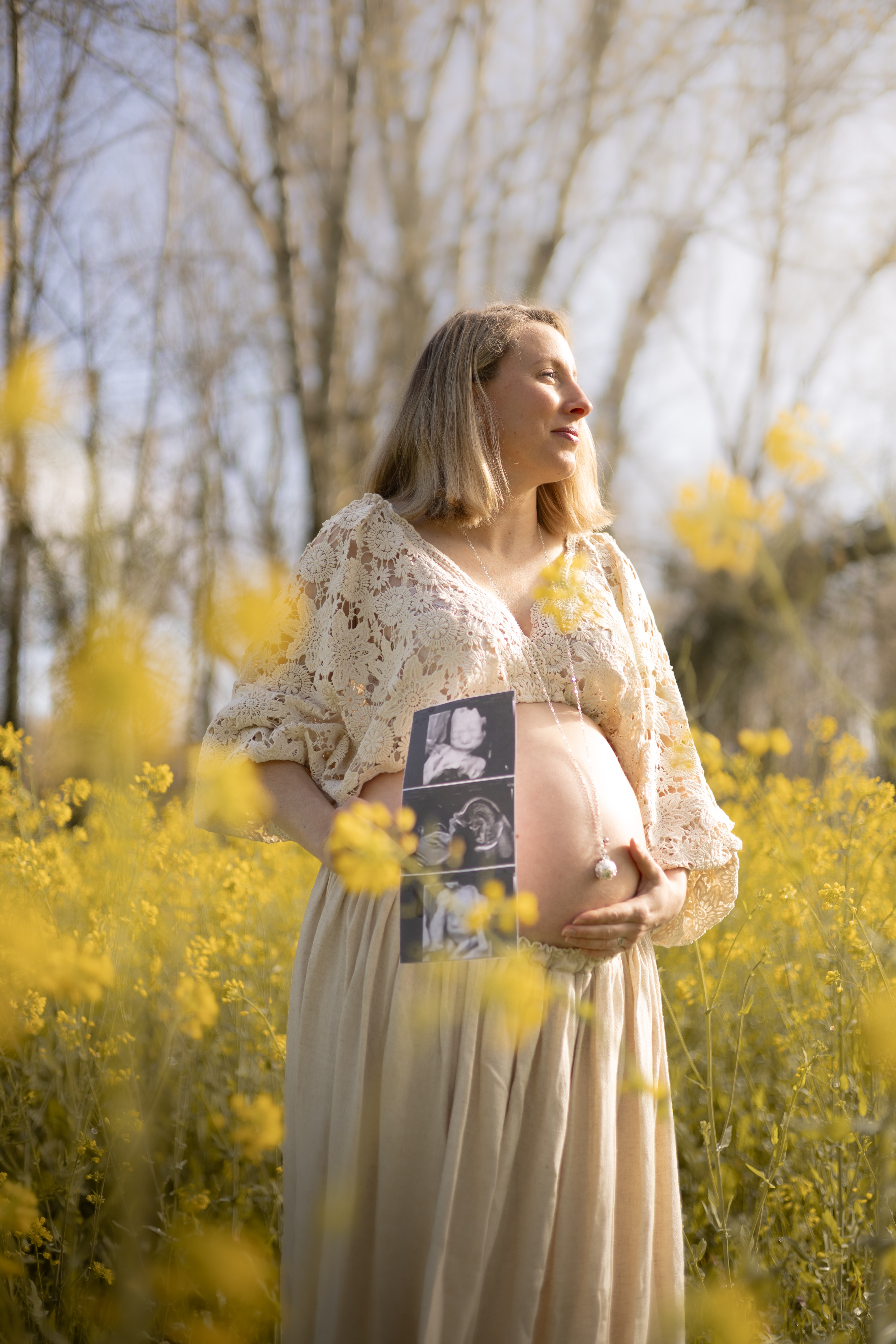 Future maman contemplant la lumière avec son échographie dans les fleurs