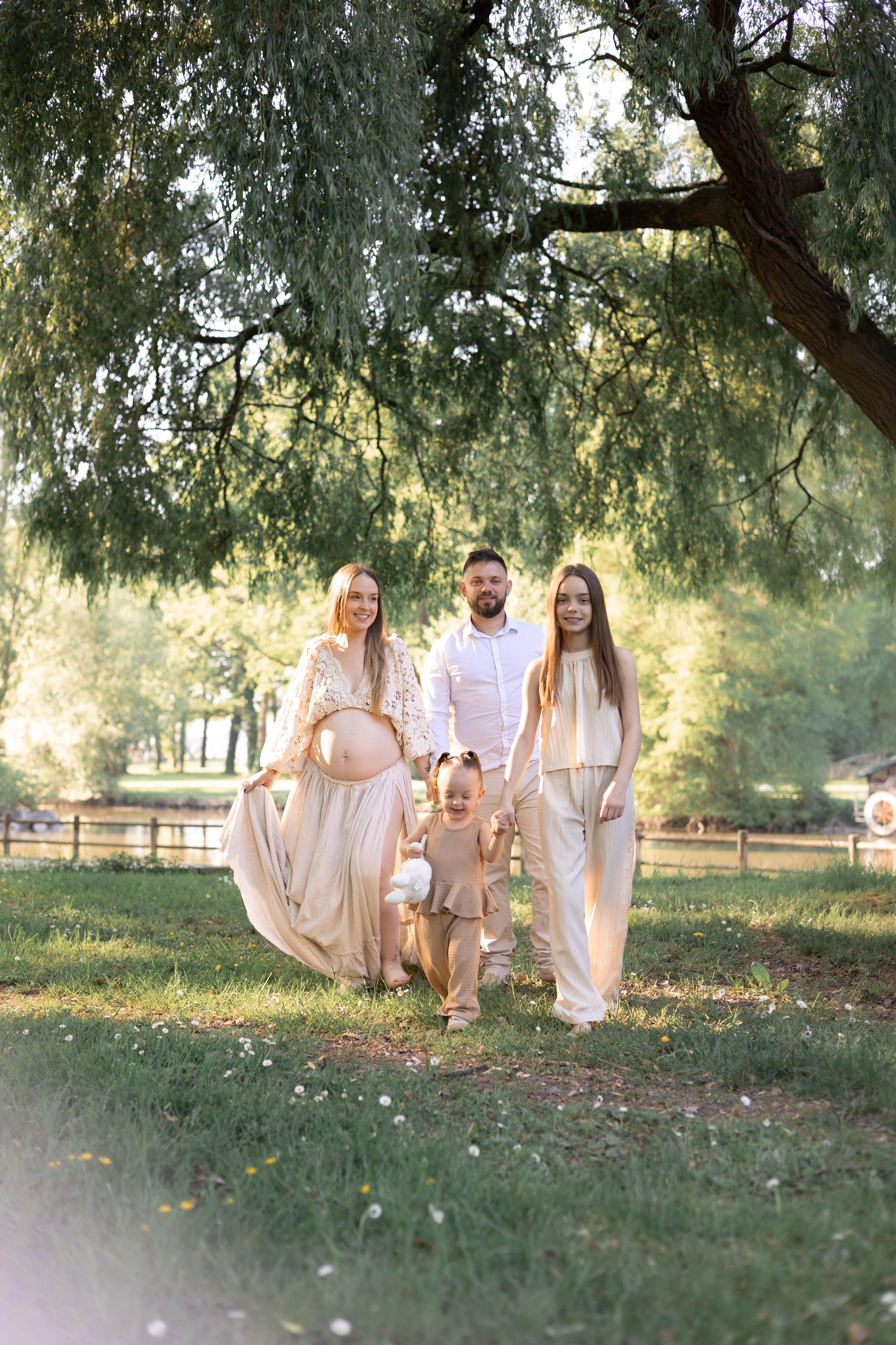 Famille marchant ensemble sous les arbres dans une lumière d’été