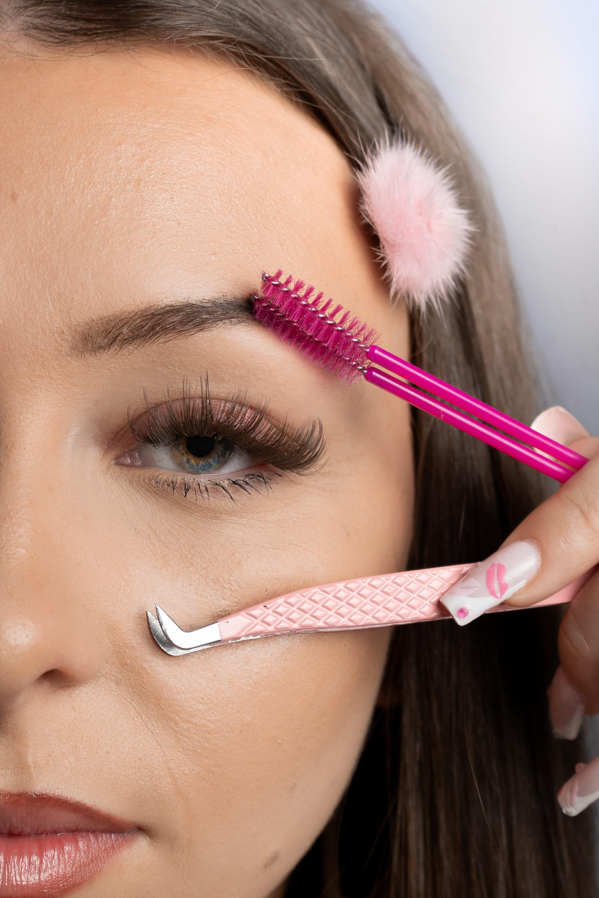 Gros plan beauté avec une brosse rose et un accessoire près de l’œil